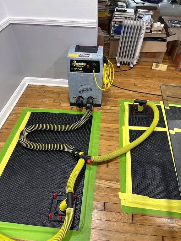 A hardwood floor drying system with extraction mats and hoses in place