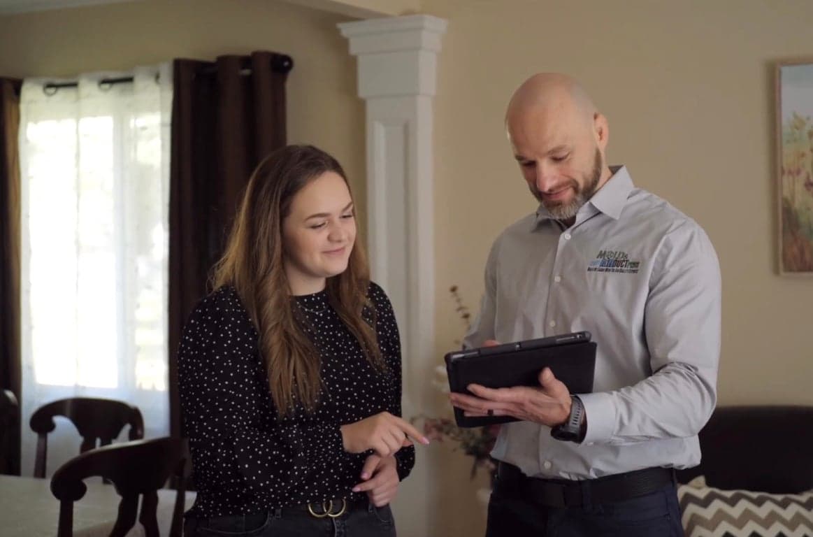 A Mold and Air Duct Pros specialist reviewing a mold assessment with a homeowner