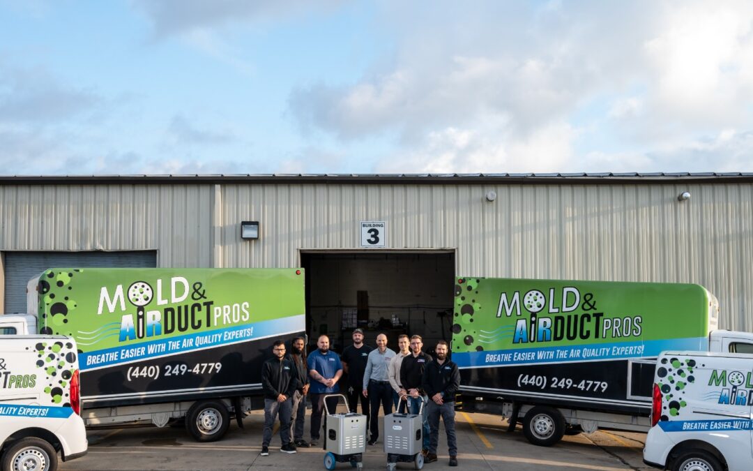 The team from Air Duct Pros, posing by their work trucks