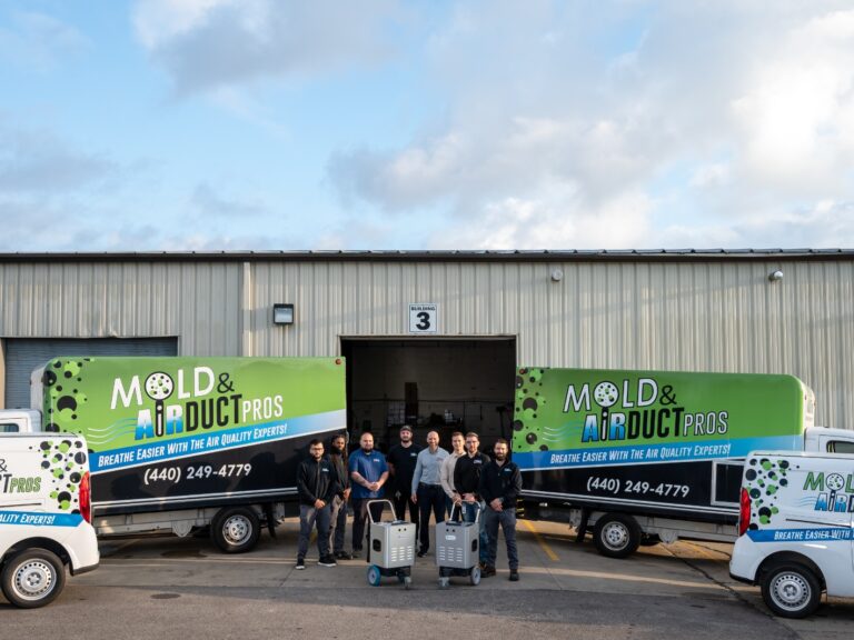 The team from Air Duct Pros, posing by their work trucks