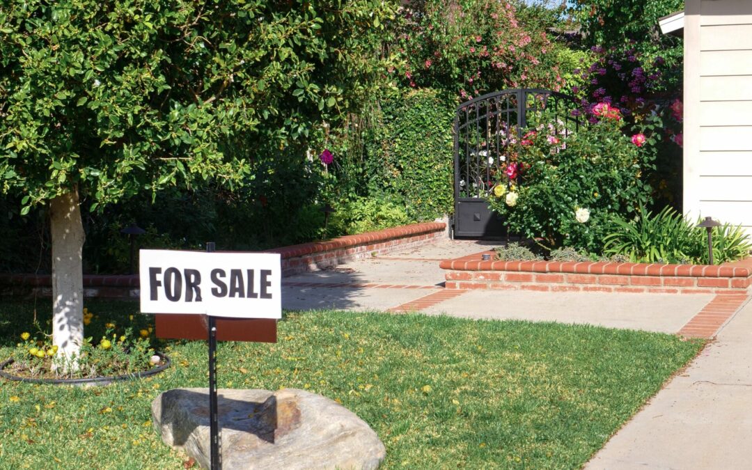 A “For Sale” sign outside of a suburban home.