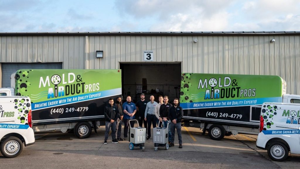The team from Air Duct Pros, posing by their work trucks